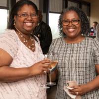 2 women pose for picture in dresses